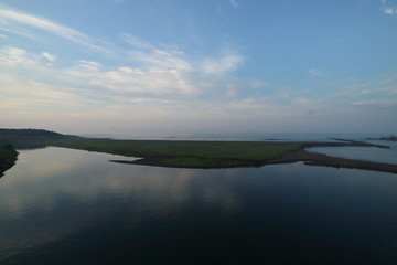 Fototapeta na wymiar 朝の雲が映り込む河口の水面