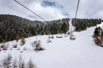 Fototapeta na wymiar View from Hatsvali Khatsvali ski resort cableway in winter. Cables, forest and mountain Ushba. Mestia, Georgia