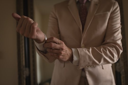 Man wears cuff-links on a shirt sleeve