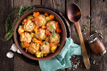 Meatballs stewed with vegetables on wooden table, top view