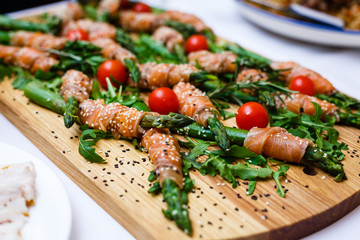 rolls of red fish and rucola on a banquet table