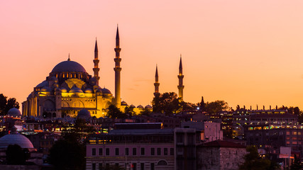 Fototapeta na wymiar Istanbul cityscape with Suleymaniye mosque with tourist ships floating at Bosphorus at night