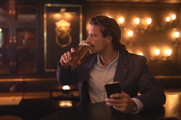 Man using mobile phone while having beer
