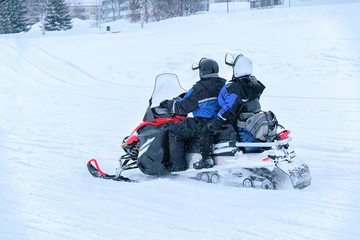 People riding snowmobile on frozen snow lake in winter Rovaniemi