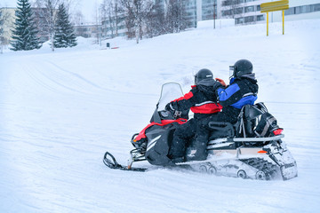 Fototapeta na wymiar People riding snowmobile in frozen snow lake in winter Rovaniemi