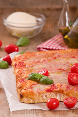 Italian pizza with cheese, tomatoes and fresh basil. 