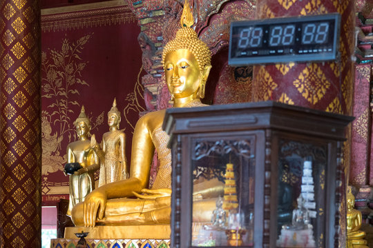 golden buddha with chronometrer in buddhist temple. thailand