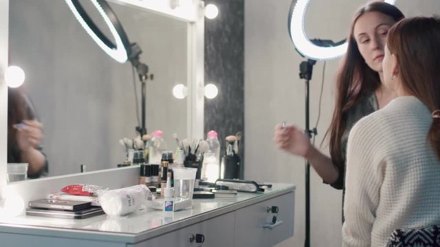 Make-up artist doing makeup for model before photo session