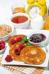 delicious pancakes with fresh raspberries and jam for breakfast, vertical closeup