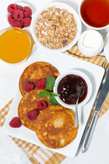 delicious pancakes with raspberries and jam for breakfast, vertical top view