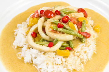 Squid rings in chilli curry sauce with green beans, tomatoes, peppers. Served with rice. Thai food.