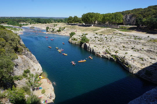 People spending time for holiday in the river by using cannoe in Pont du Gare in France. One of the most popular touristic destination during summer season in Europe.
