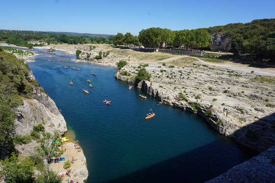 People spending time for holiday in the river by using cannoe in Pont du Gare in France. One of the most popular touristic destination during summer season in Europe.