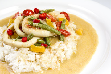 Squid rings in chilli curry sauce with green beans, tomatoes, peppers. Served with rice. Thai food.