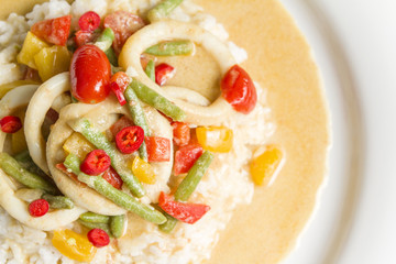 Squid rings in chilli curry sauce with green beans, tomatoes, peppers. Served with rice. Thai food.