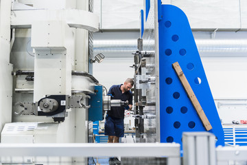 Man working on machine in industrial factory
