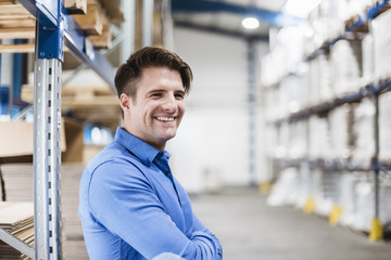 Businessman standing in warehouse, portrait