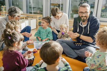 Children and teachers playing and making music in kindergarten