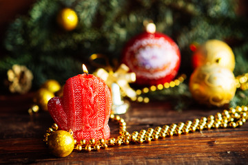 Christmas gift boxes on red scarf and candle on bokeh lights background.