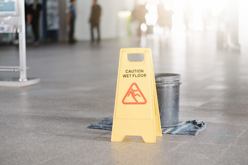 Sign showing warning of caution wet floor at airport