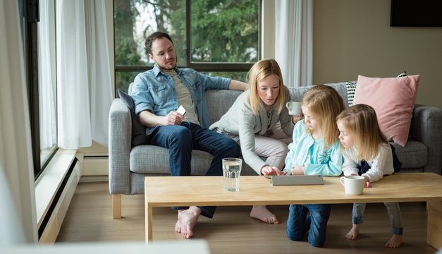 Family Using Digital Tablet In Living Room