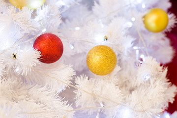 Fototapeta na wymiar Christmas decoration with Christmas gold and red balls hanging on white snowflakes tree background.