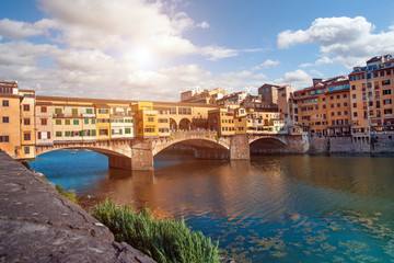 Beautiful city view with the famous medieval stone bridge Ponte Vecchio over the Arno river in Florence, Italy. Place of pilgrimage for tourists.