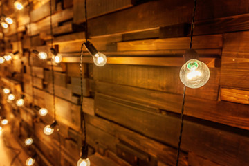 Hanging light bulb over the wooden background, mockup poster. Background wood planks with lamps