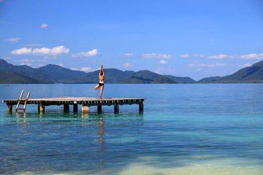 undefined woman play yoga by the sea among  island in southern of thailand