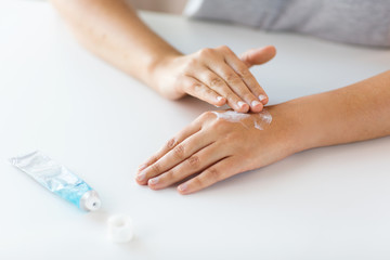 close up of hands with cream or therapeutic salve