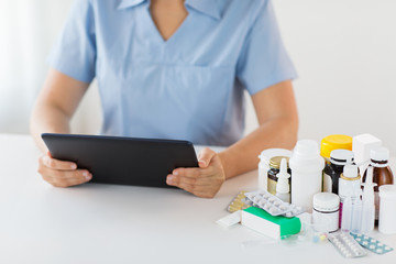 nurse or doctor with medicines and tablet pc