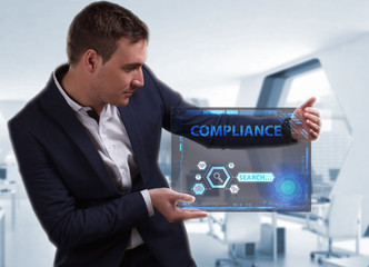 Business, Technology, Internet and network concept. Young businessman working on a virtual screen of the future and sees the inscription: Compliance
