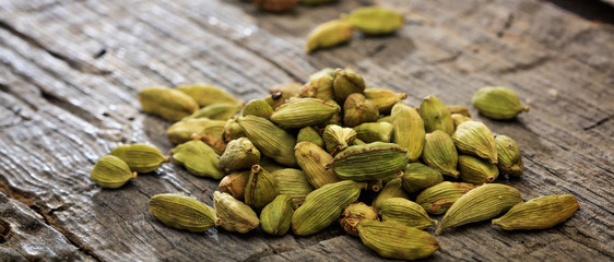 Cardamom pile set on old wooden surface. Close up view with details.