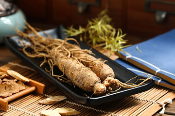 .ginseng in black plate on wooden table