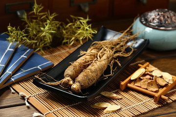 .ginseng in black plate on wooden table