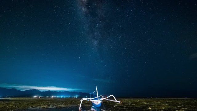 The fishing boat is aground against the background of the milky way timelapse