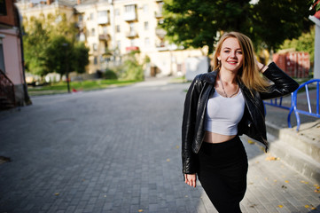 Obraz premium Elegant blonde girl wear on black leather jacket posing at streets of town.