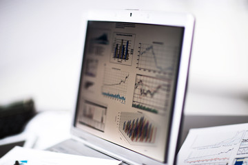 Obraz premium Businessman analyzing investment charts with laptop.