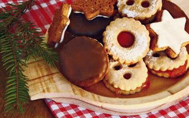 Mixed a lot kind of Christmas cookies on wooden dish.