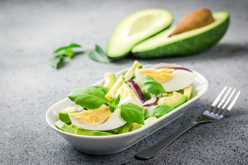 Clean eating avocado egg salad on stone or concrete background. Selective focus, close up, space for text. 