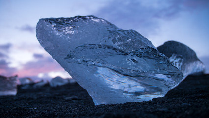 Glacial fragment of ice on black beach at sunset, Jokulsarlon Iceland