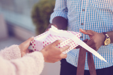 Nice surprise. Close up of a pink gift box with a nice surprise inside being given to a beautiful young woman during the date