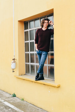 Cool man standing in front ad a window