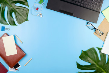 Beautiful flatlay with a laptop, glasses, philodendron leaves and other business accessories....