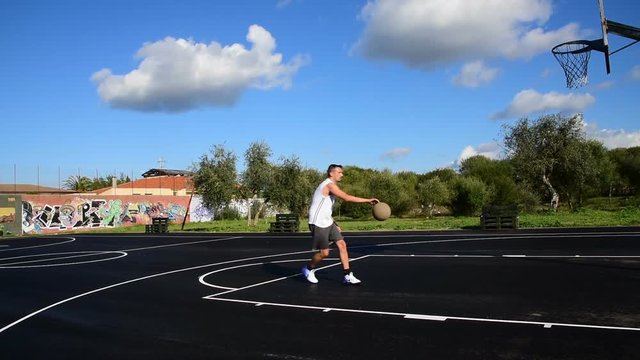 Basketball player working out in playground on a cloudy day