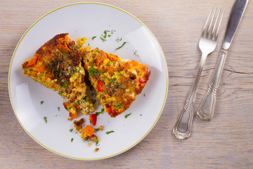Frittata made with  eggs, beef sausage, pumpkin (or butternut squash) and red bell pepper. View from above, top, horizontal