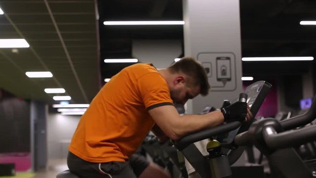 Fit man working out on exercise bike at the gym