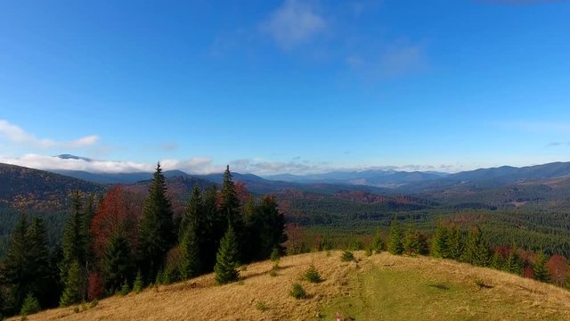 Aerial View. Flying over the high autumn mountains in beautiful clouds . Aerial camera shot. Air clouds
