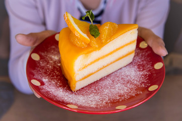 Tasty orange fruit cake on red christmas patt dish for ready to eat