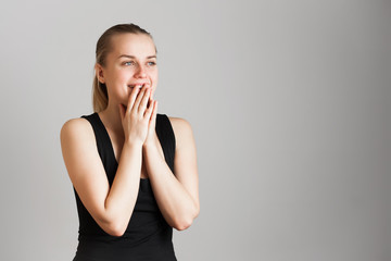 Portrait of young surprised girl over grey background. Copy space.